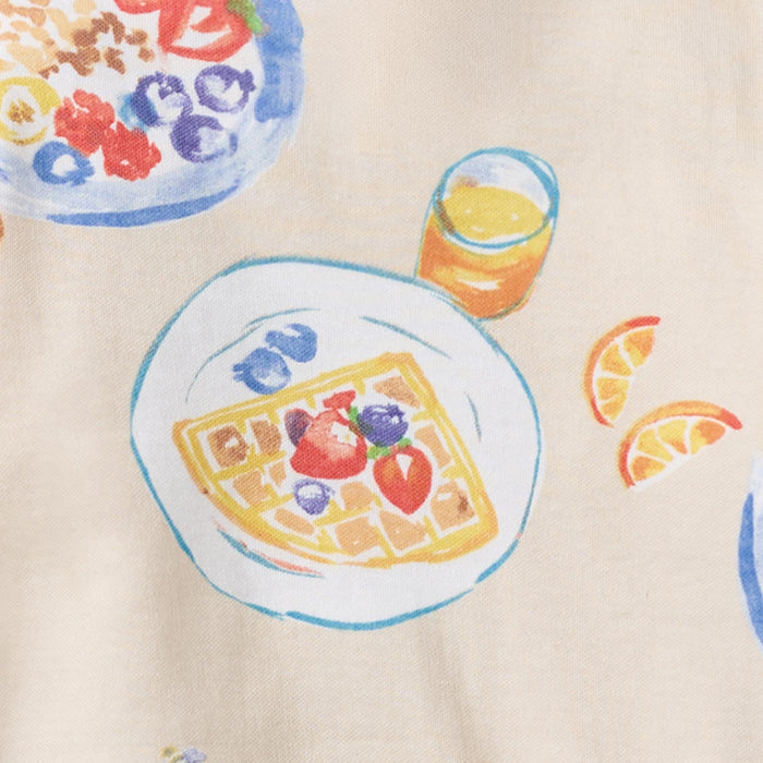 Cream footed pajamas fabric with colorful food and fruit print, plate and drink graphics
