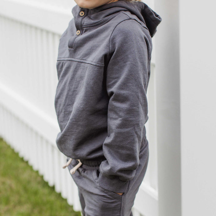 Dark gray organic cotton hoodie worn by child, long sleeves and ribbed hem
