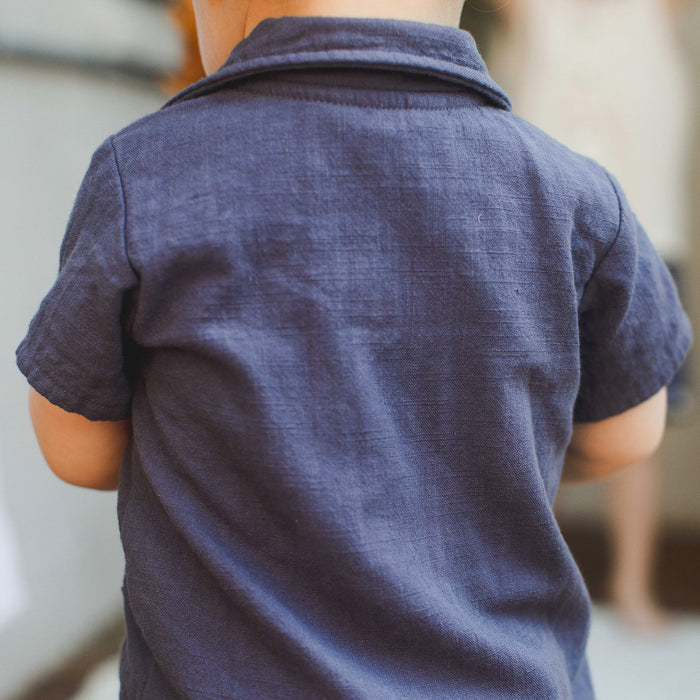 Back view of navy checked gauze baby boy romper with short sleeves