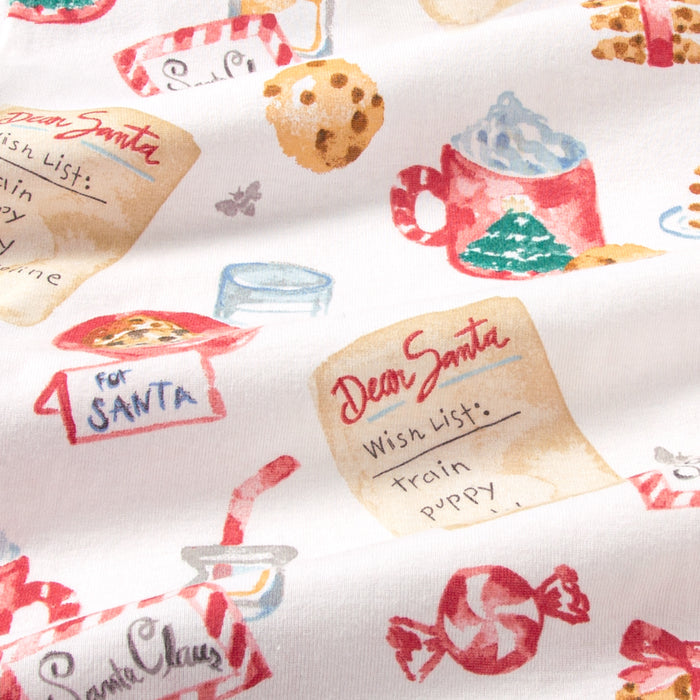 Close-up of white pajama fabric with Santa cookie wish list and candy cane prints