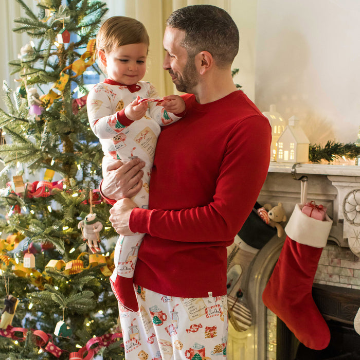 Kids footed sleeper with long sleeves and Santa cookie holiday pattern, full-body view.