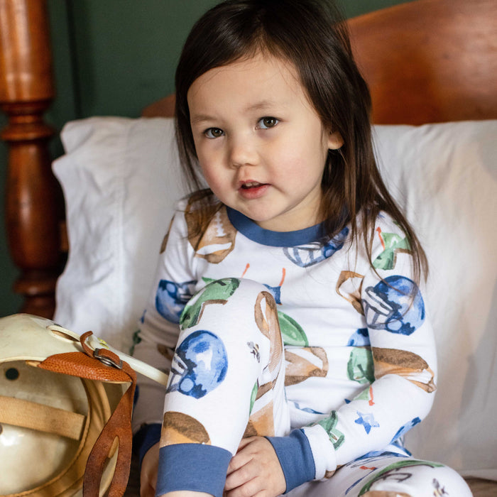 Kids pajama set on child: white football print top and pants with blue cuffs