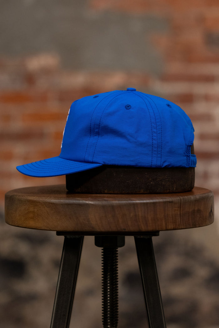 Franklin & Poe Surf Cap - Nylon Royal Blue on stool, facing the side