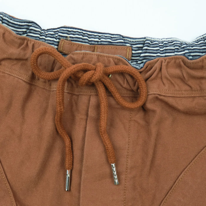 shorts laid flat on white, from the front. Close up on waist string