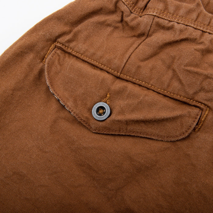 shorts laid flat on white, from the back. Close up on back pocket button