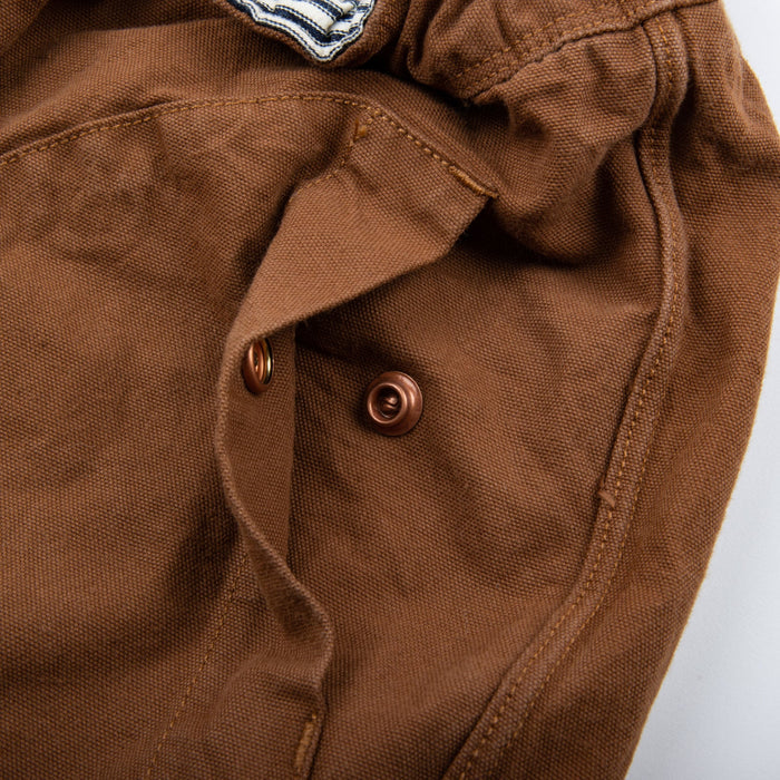 shorts laid flat on white, from the front. Close up on front pocket snaps
