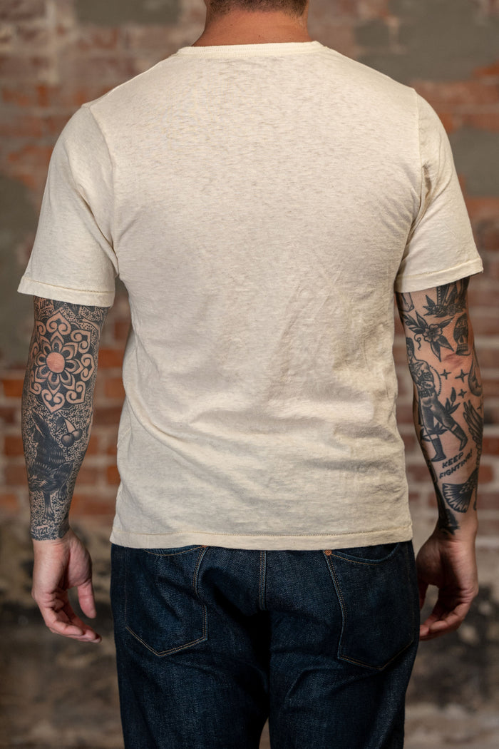 A man viewed from behind, wearing 
Freenote Cloth Fairmont S/S - Natural from the back - this is a light beige heathered cotton t-shirt