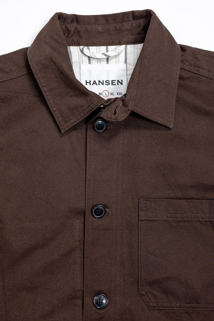 Hansen Garments Bendik Workwear Jacket - Chestnut - product shot - front facing - white background - close up detail of collar, buttons, and pocket.