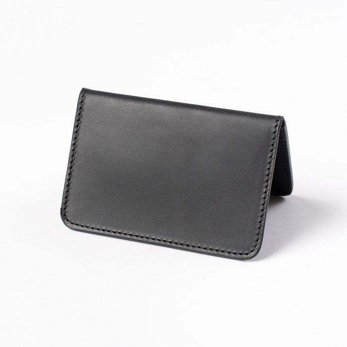 Obbi Good Label Kingsman Metro Flap Style Cardholder - Black - A black leather cardholder, displayed open, inside facing down, showcasing smooth external side against a white background