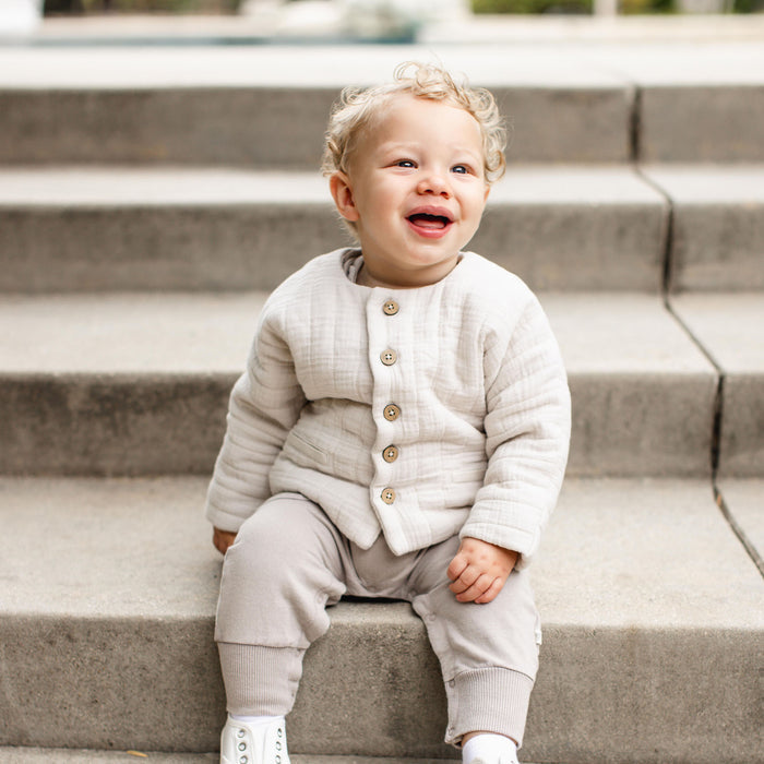 Off-white quilted organic cotton jacket with button front and long sleeves on child