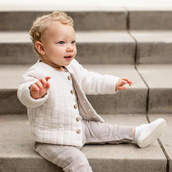 Off-white quilted organic cotton jacket with wood-look buttons and long sleeves on child