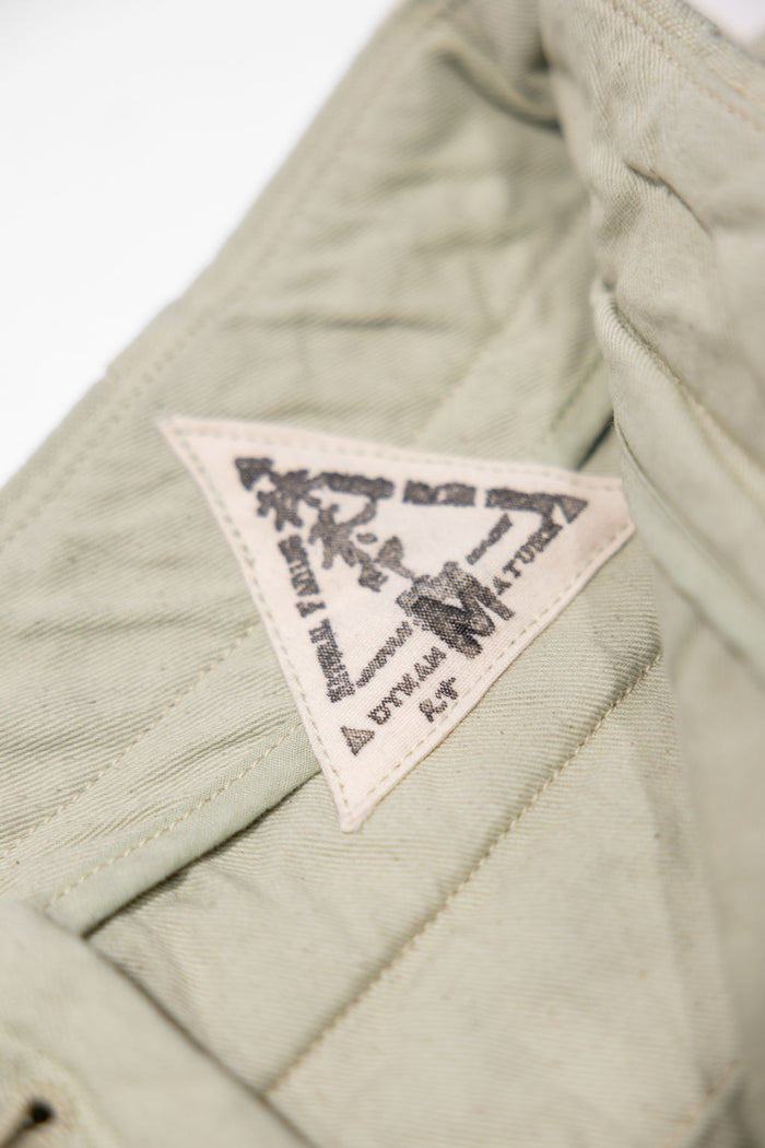 Seuvas Canvas Tapered 2-Tuck Pants (Regular) - Matcha. close up detail shot of inside tag