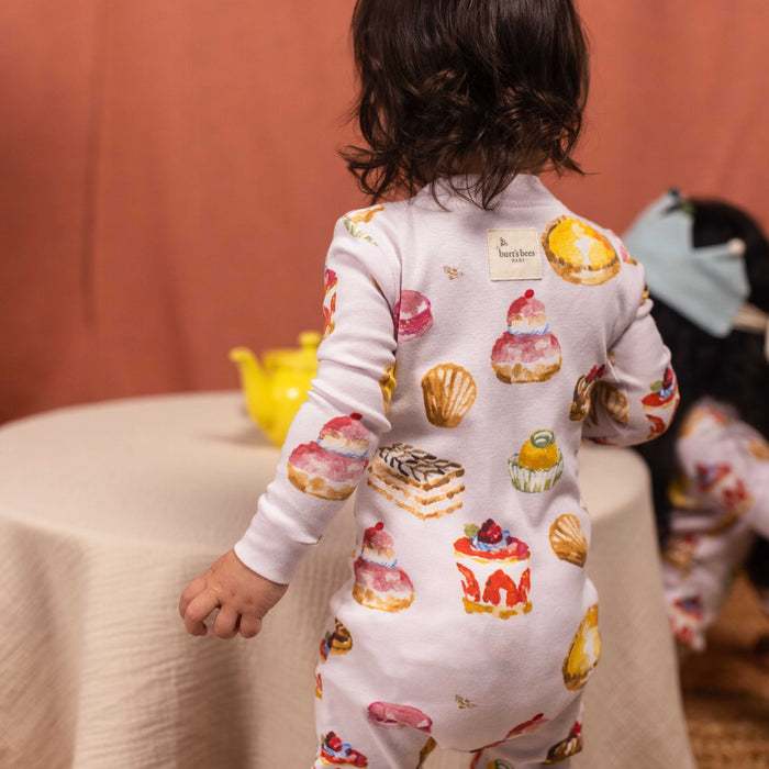 Back view cream footed pajama with bakery print, long sleeves, snap buttons