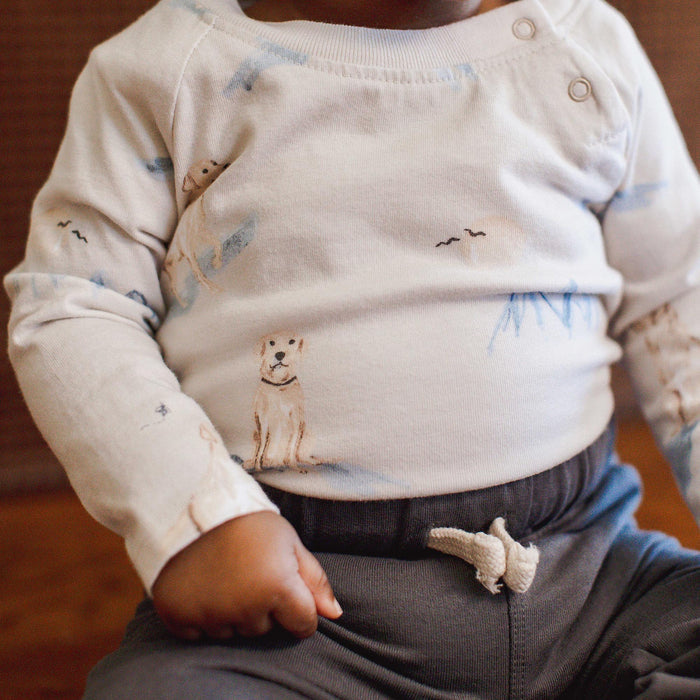 Cream baby boy bodysuit with dog graphic and snap-button neckline, long sleeve