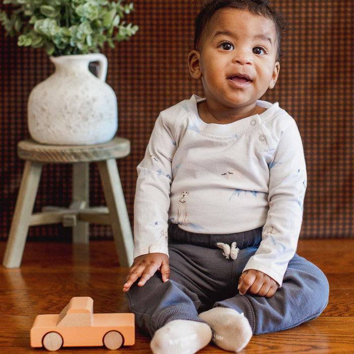 Cream baby boy bodysuit with long sleeves and dog print, snap-button neck