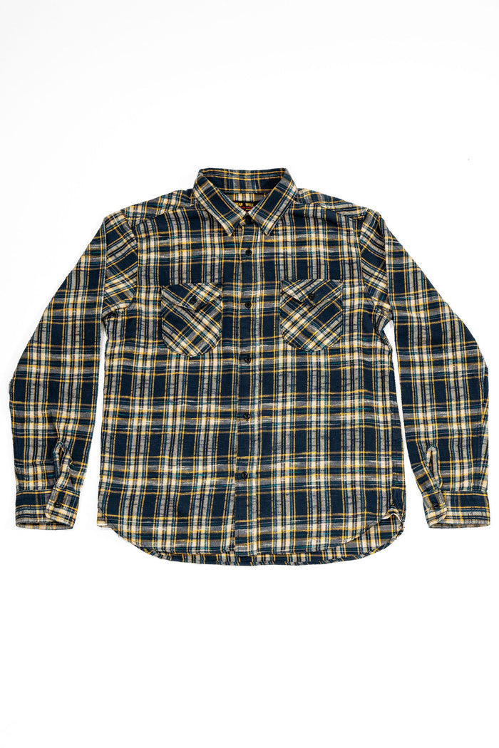 UES 502655 Slubby Flannel Shirt - Navy A long-sleeve plaid button-up shirt in navy blue, beige, and yellow, laid flat against a white background.