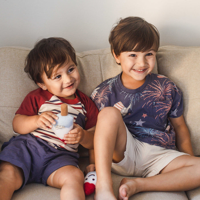 Boys striped raglan tee and navy shorts set worn by two kids sitting