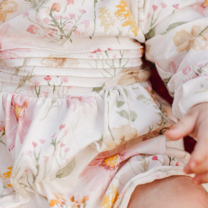 White floral cotton dress detail showing gathered waist seam and skirt ruffle